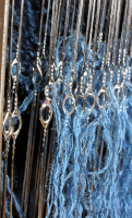 Closeup of metal heddles and warp threads