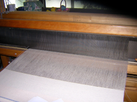 Wide shot of metal reed with warp threads